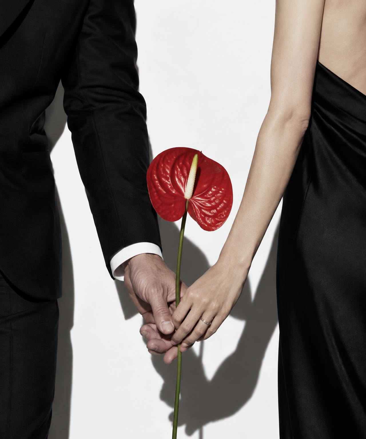 Black formalwear and a red anthurium in an editorial wedding portrait